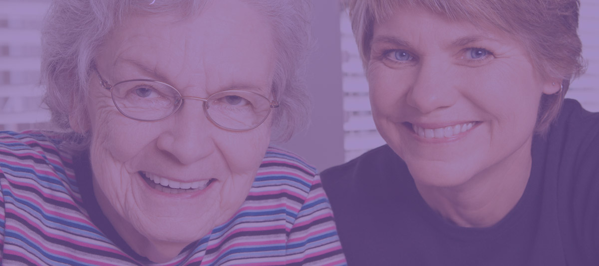 Two women smiling together, including an older adult